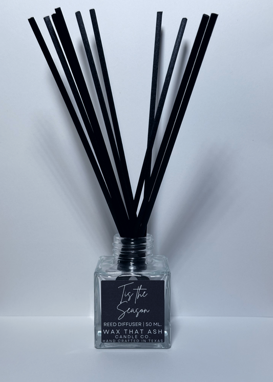 Reed diffuser with black sticks and a clear bottle labeled 'Is it the Season' on a white background.