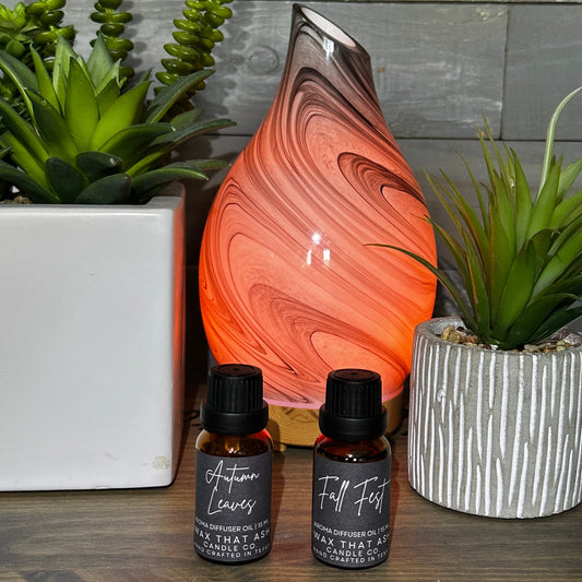 Decorative lamp with marbled design on a wooden surface with two small bottles and plants.